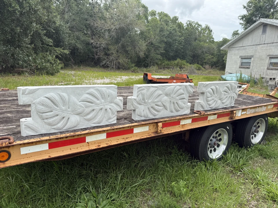 Multiple concrete garden-bed panels arranged on a flatbed trailer