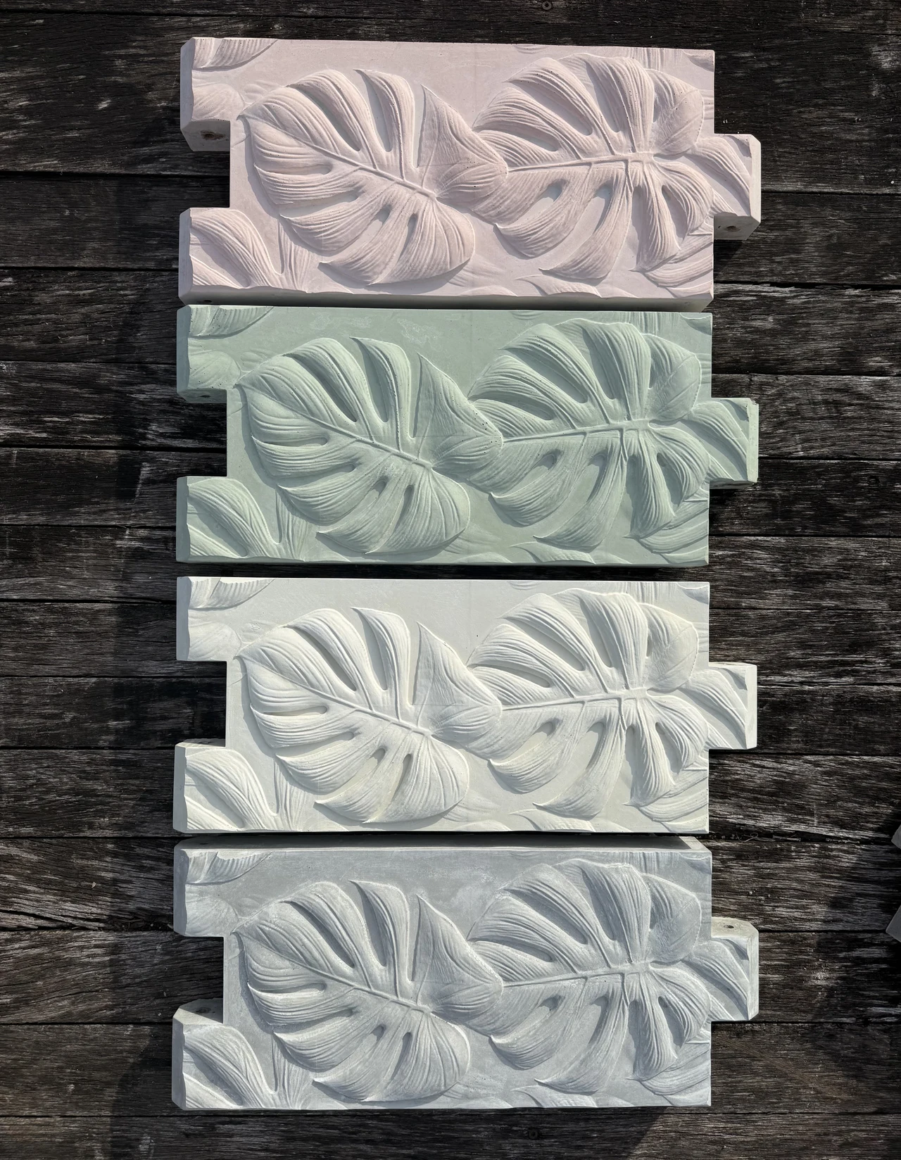 Finished botanical-relief concrete garden-bed panels in four Florida-inspired colors