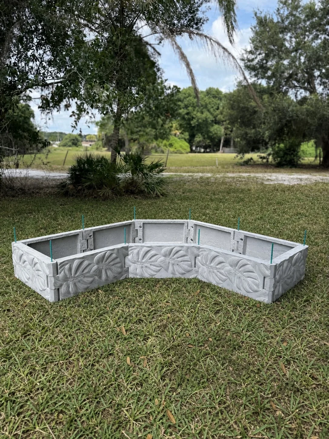 Empty curved Radical raised garden bed assembled from sculpted concrete panels