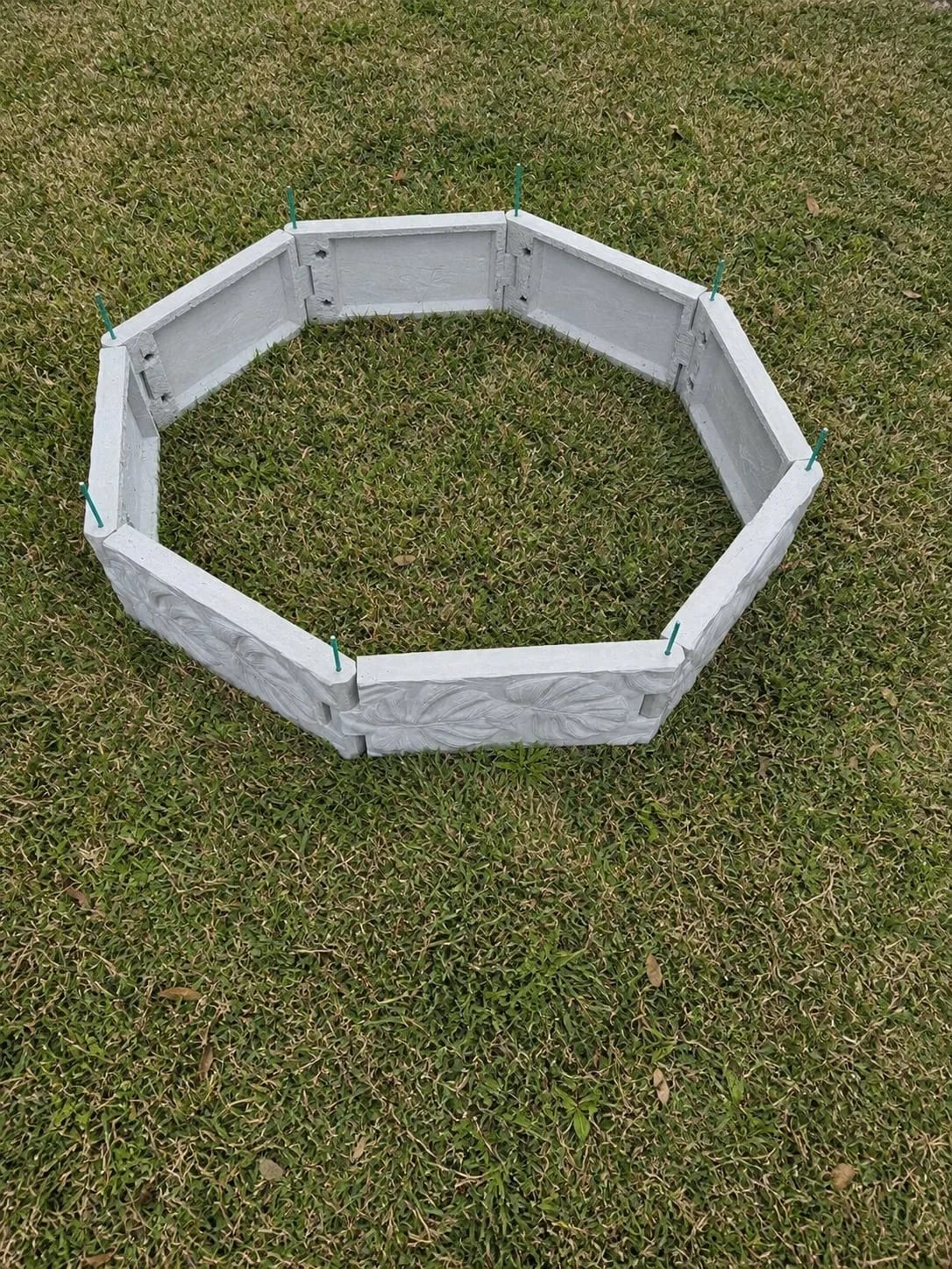 Top view of an empty octagonal Radical raised garden bed assembled on grass
